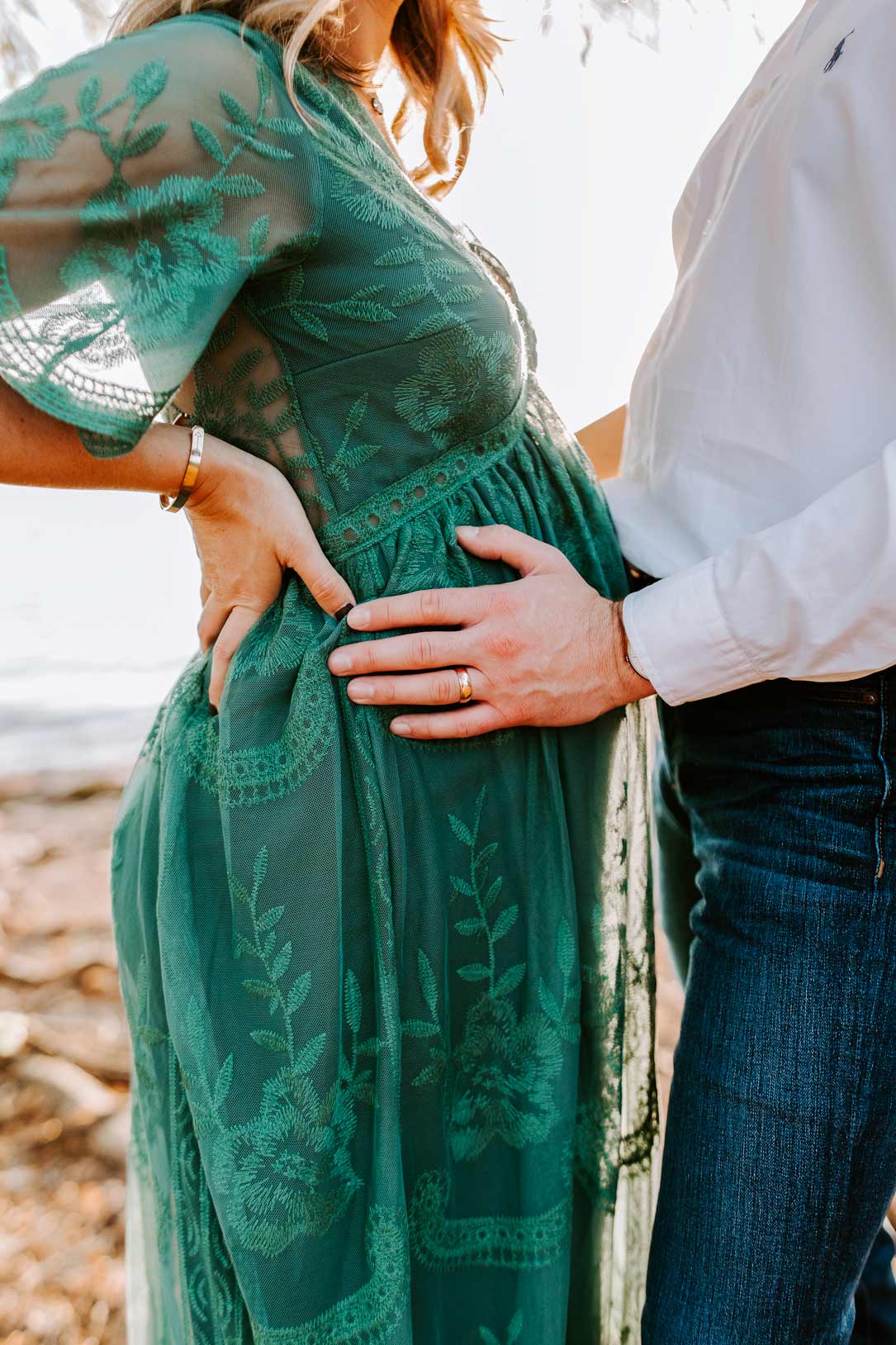 Mosie Family portrait with dad-to-be holding pregnant wife's belly on a beach