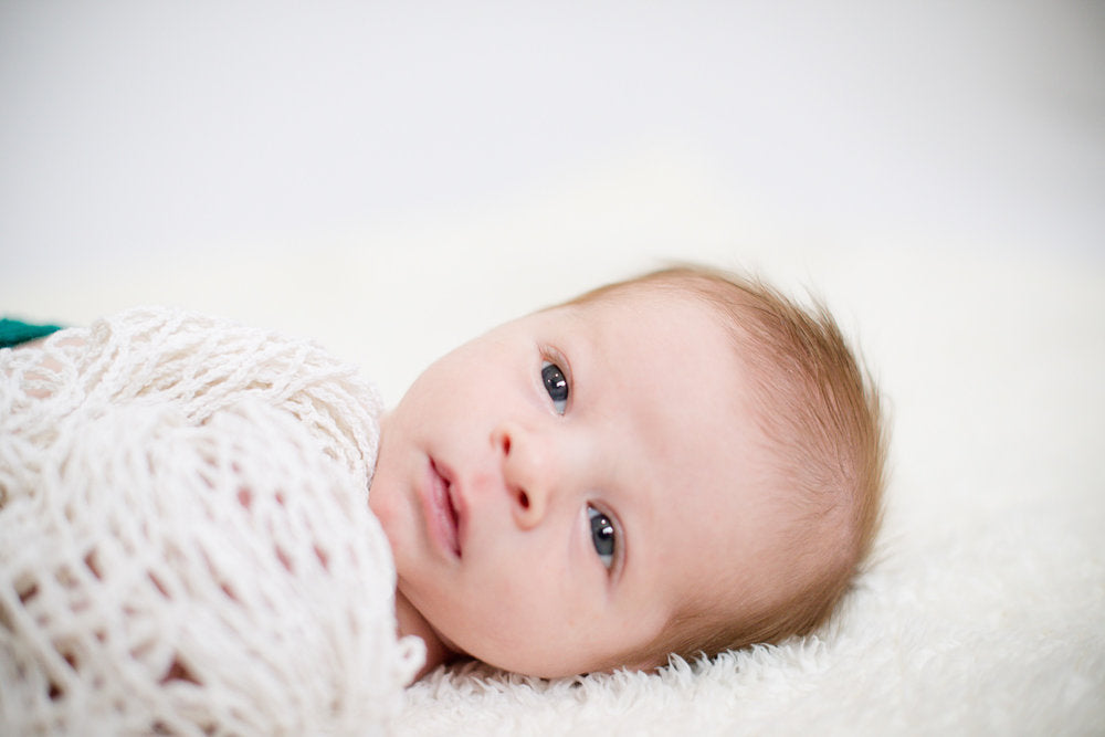 newborn mosie baby swaddled in a blanket