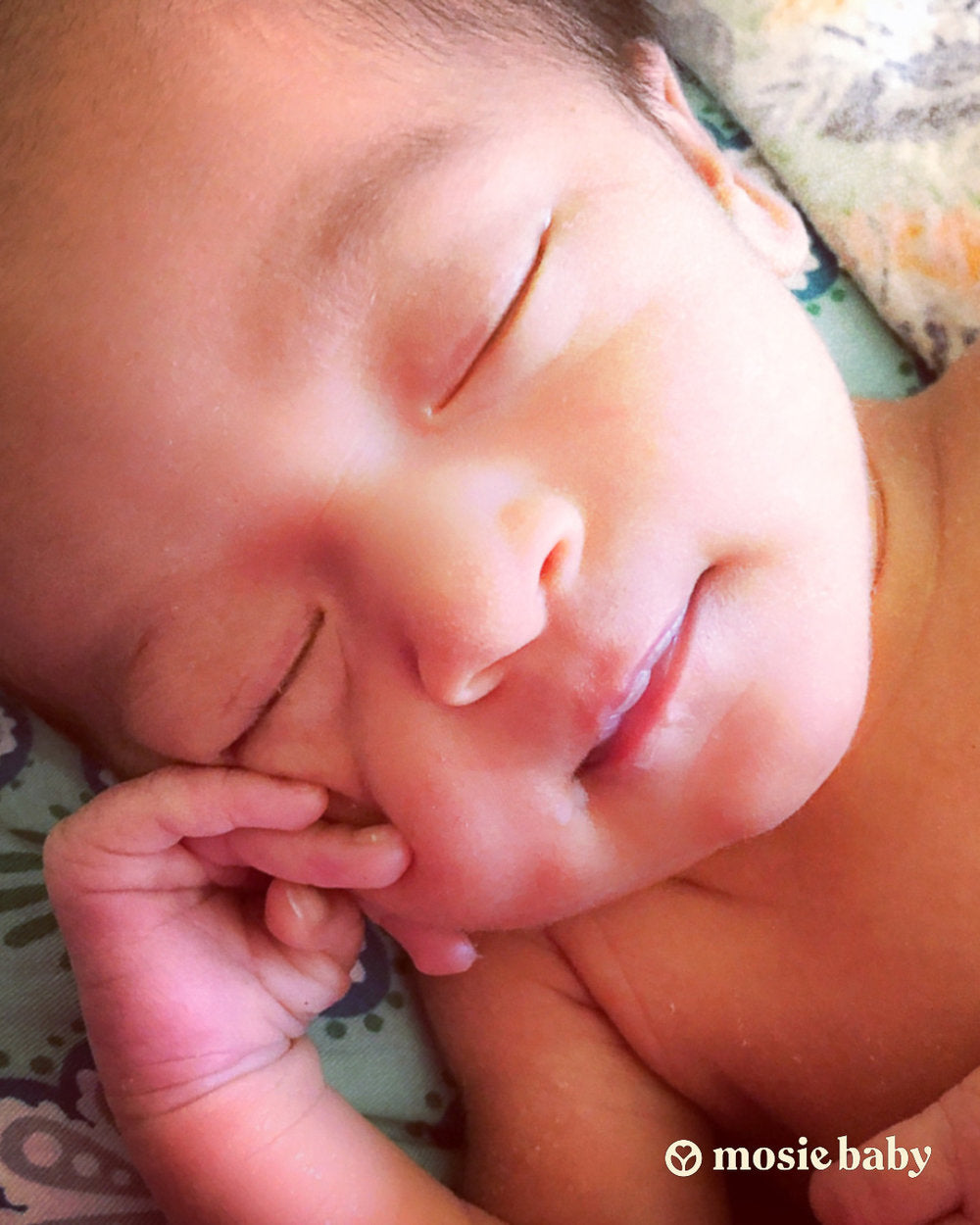A sleeping mosie baby smiling